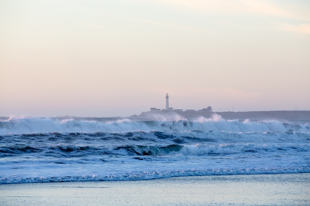 Faro con olas de mar durante el día