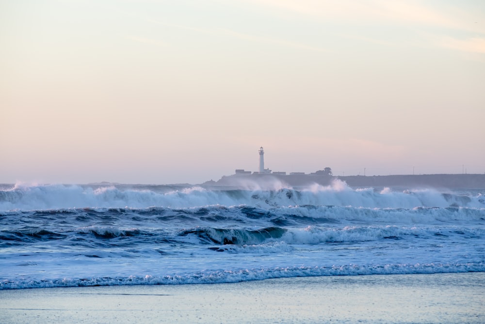 Phare avec des vagues de mer pendant la journée