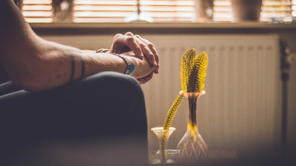 person sitting in front of yellow vase