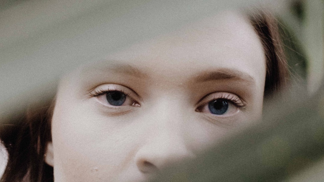 shallow focus photography of woman behind the grass