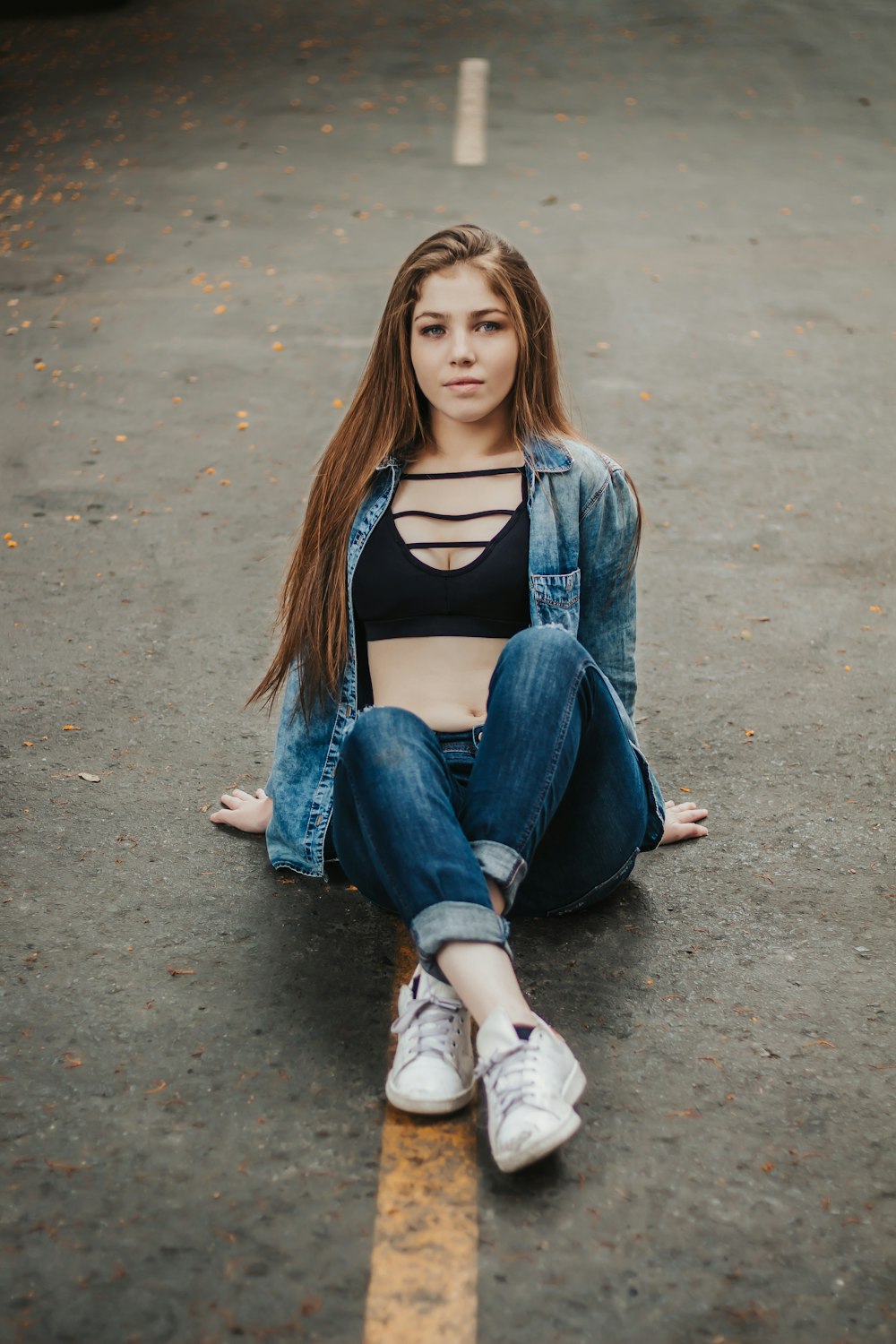 a woman sitting on the ground with her legs crossed