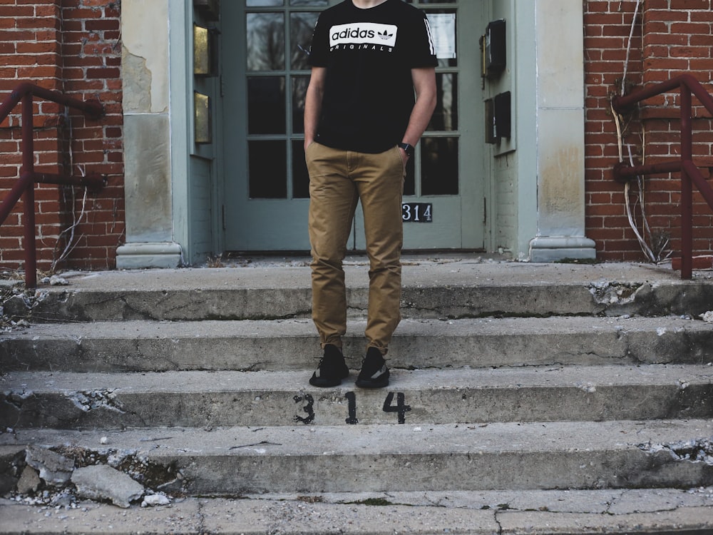 L’homme a mis sa main sur sa poche alors qu’il se tenait debout sur l’escalier