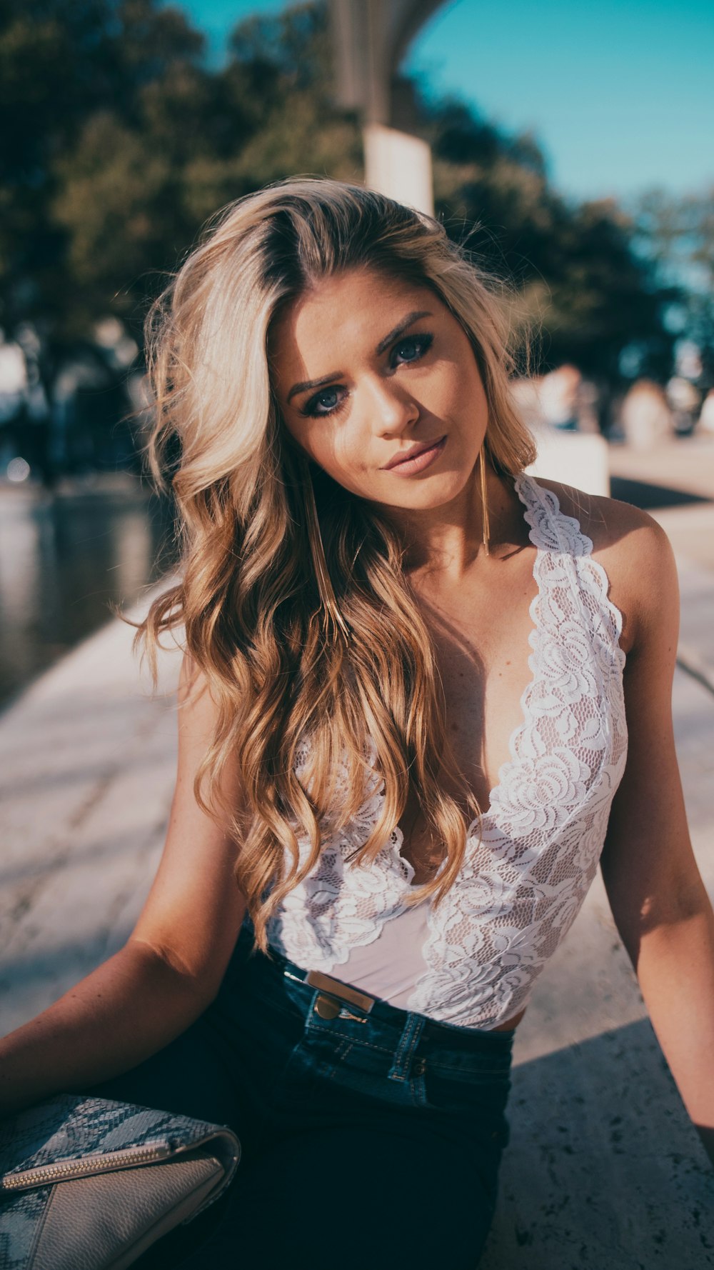 woman wearing lace halter top and blue denim jeans