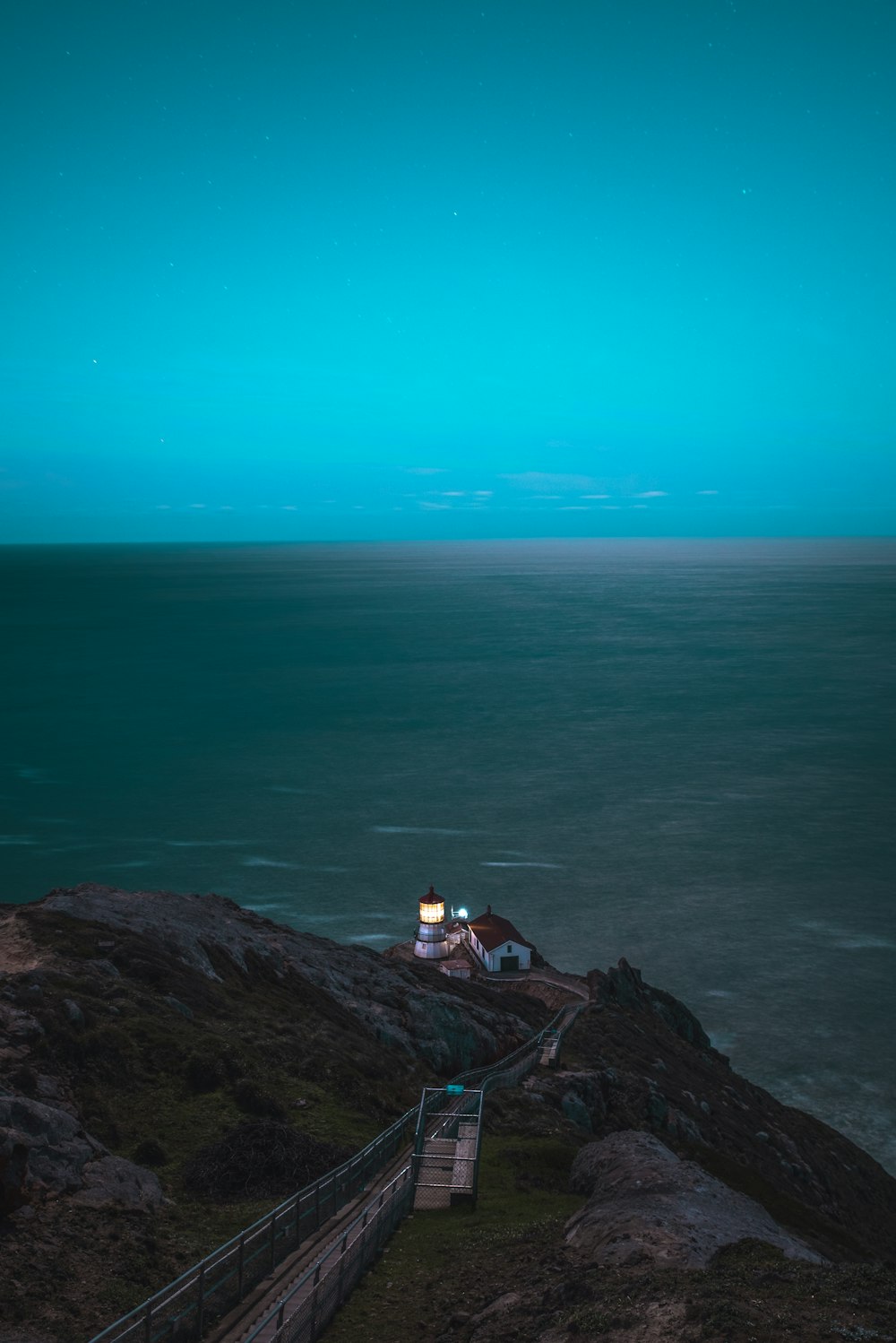 Braunes und weißes Haus auf einer Klippe vor dem Meer