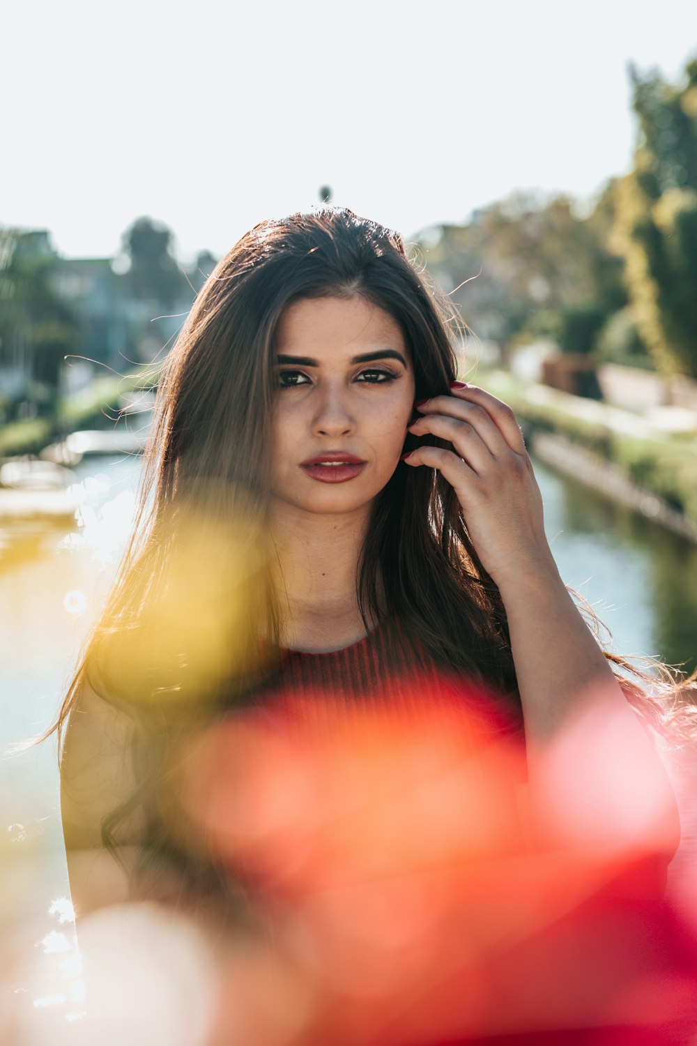 Photographie bokeh d’une femme debout près d’un plan d’eau