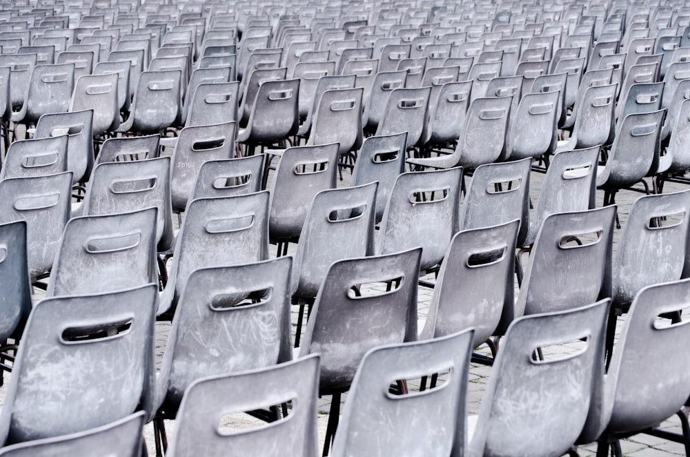 Des chaises grises alignées sur le trottoir