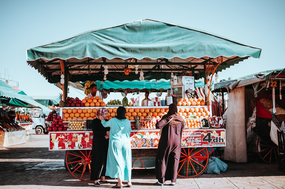 Trois femmes devant le stand de transport de fruits