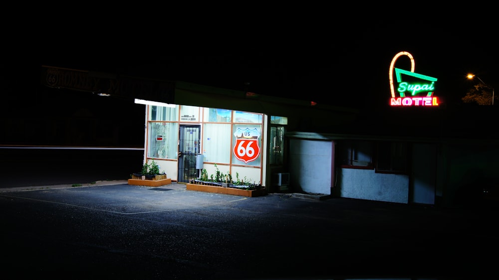 white and multicolored building near green neon signage