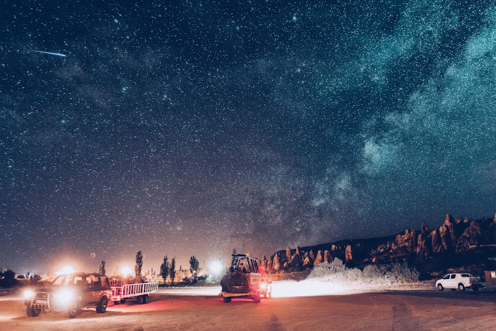 two vehicle on road near rock formation at nighttime