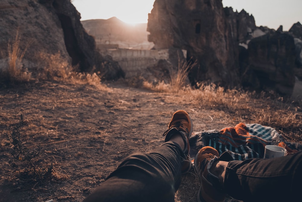 man in black pants lying down on ground