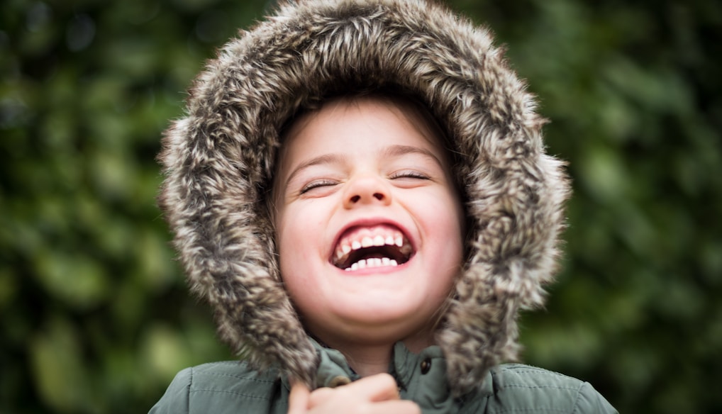 selective focus photography of child laughing