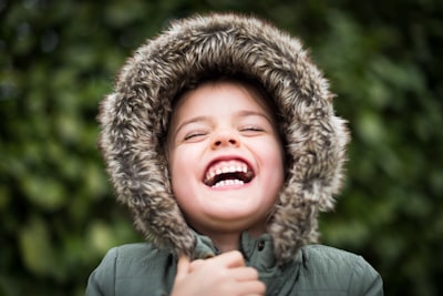 selective focus photography of child laughing joyful teams background
