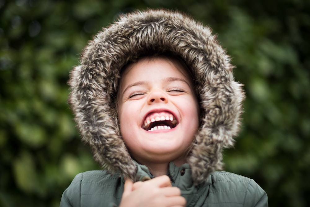selective focus photography of child laughing