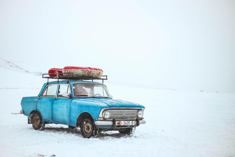 blue sedan on snow field