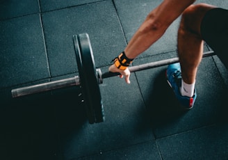 man holding black barbell