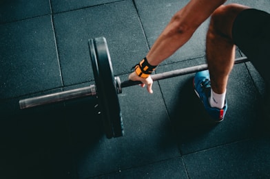 man holding black barbell