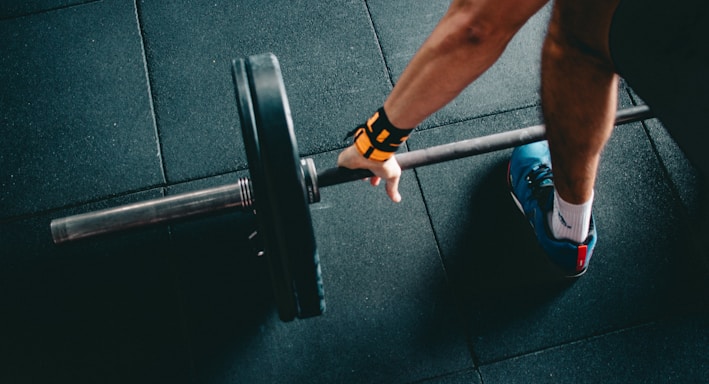 man holding black barbell