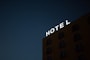 low-angle photo of Hotel lighted signage on top of brown building during nighttime