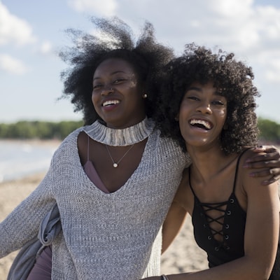 photo of woman beside another woman at seashore