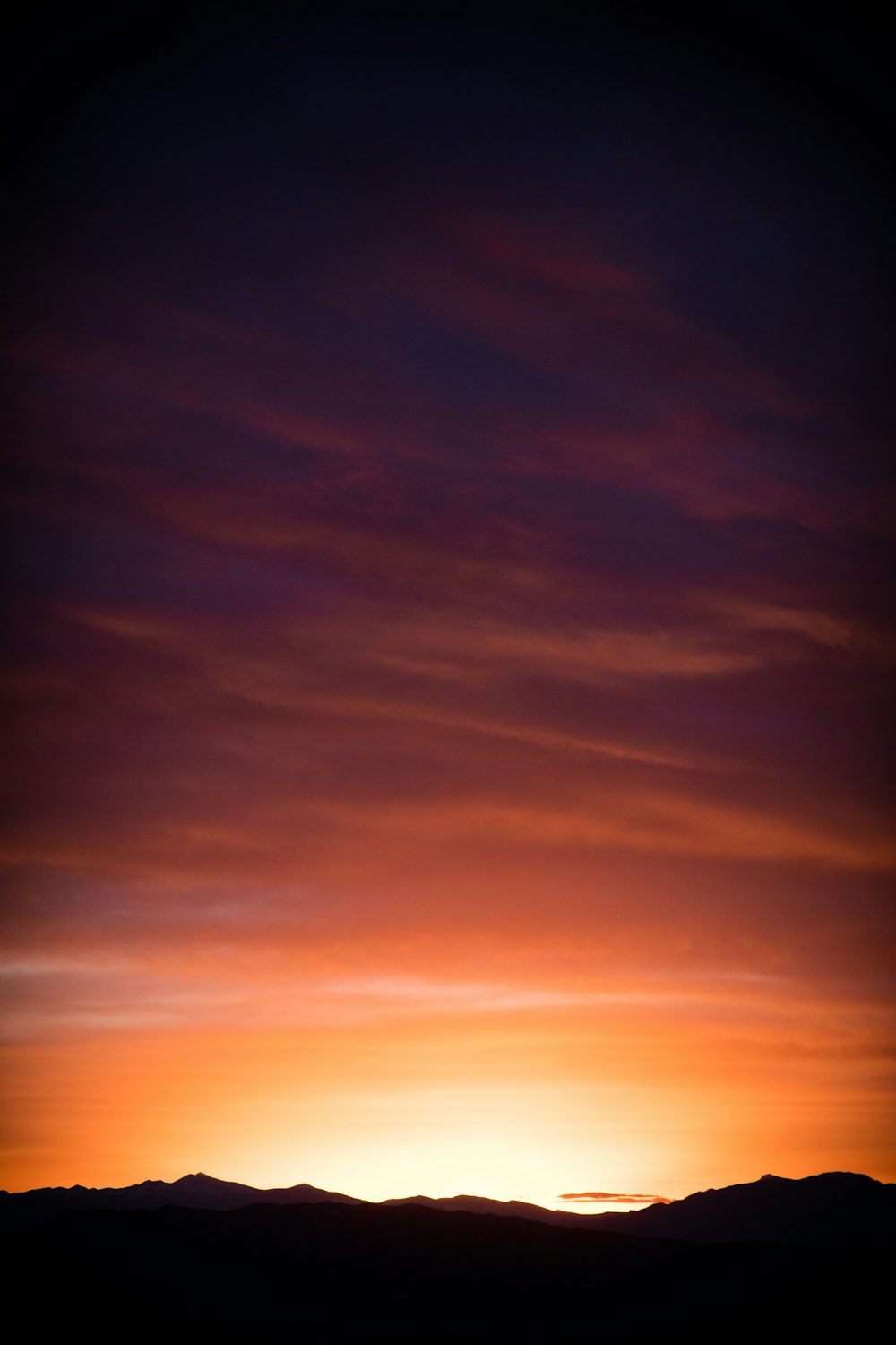 Silhouette der Berge während des orangefarbenen Sonnenuntergangs