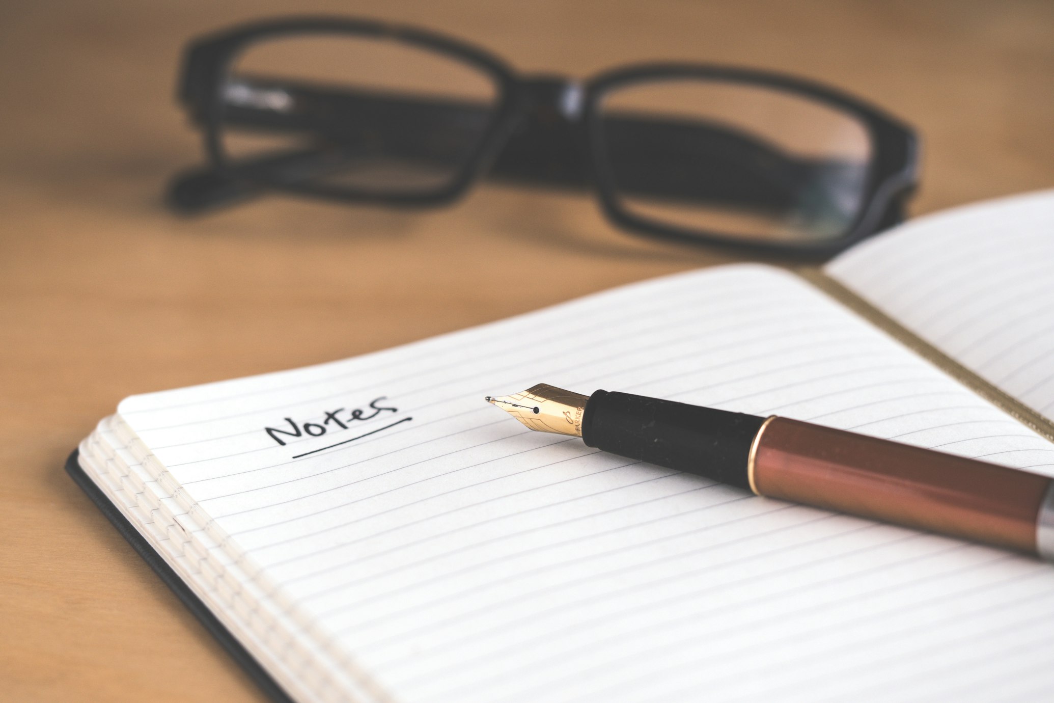 photo of a notebook and pen on a table