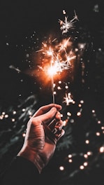 time-lapse photography of person holding firecracker