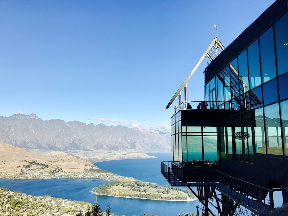 bird's-eye view photo of smoke glass wall building with calm body of water in distant