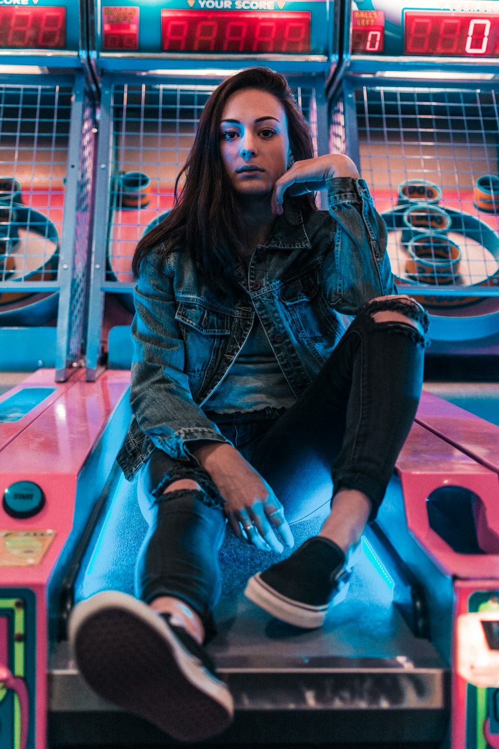 woman sitting on arcade cabinet