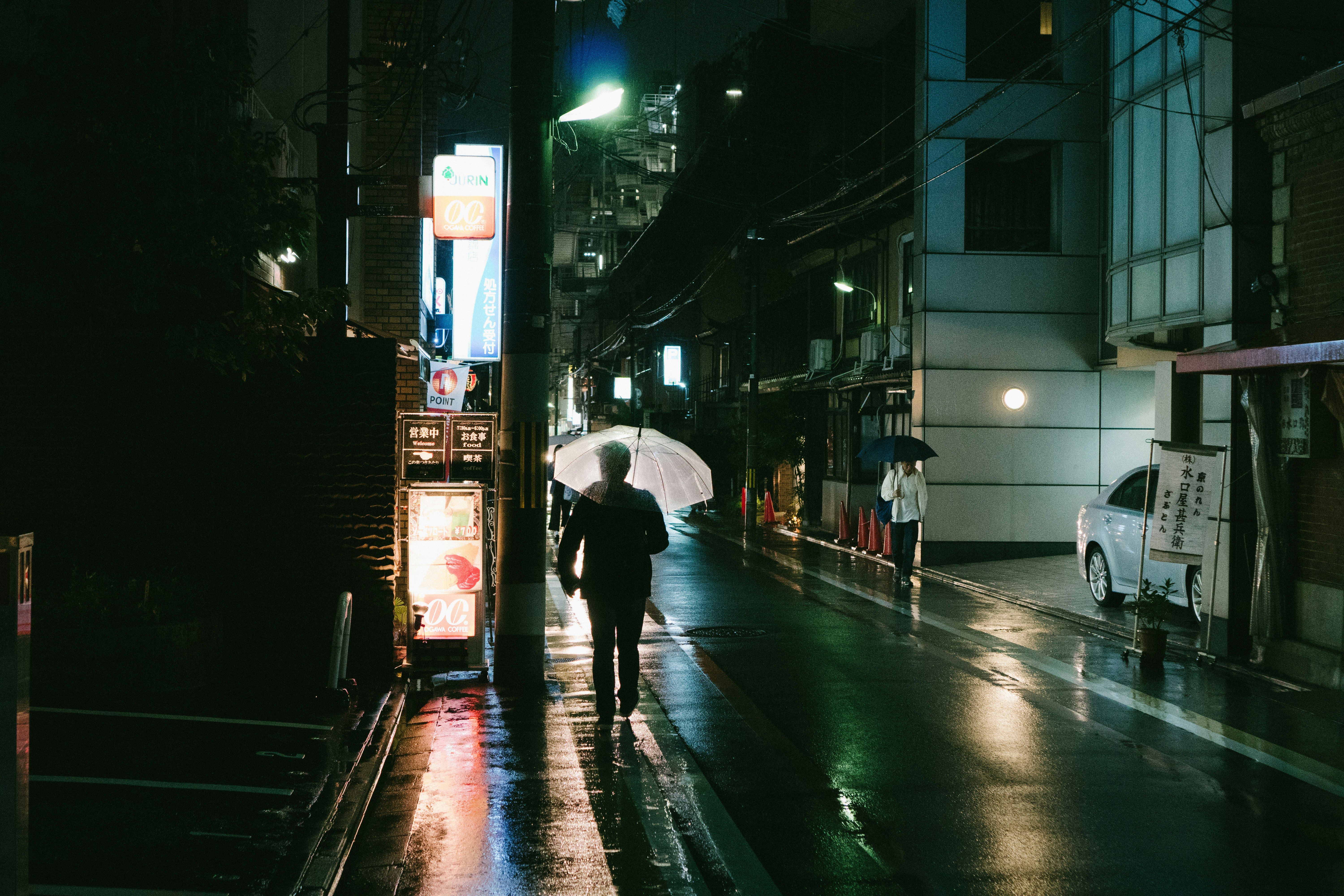 person holding umbrella near building at night time