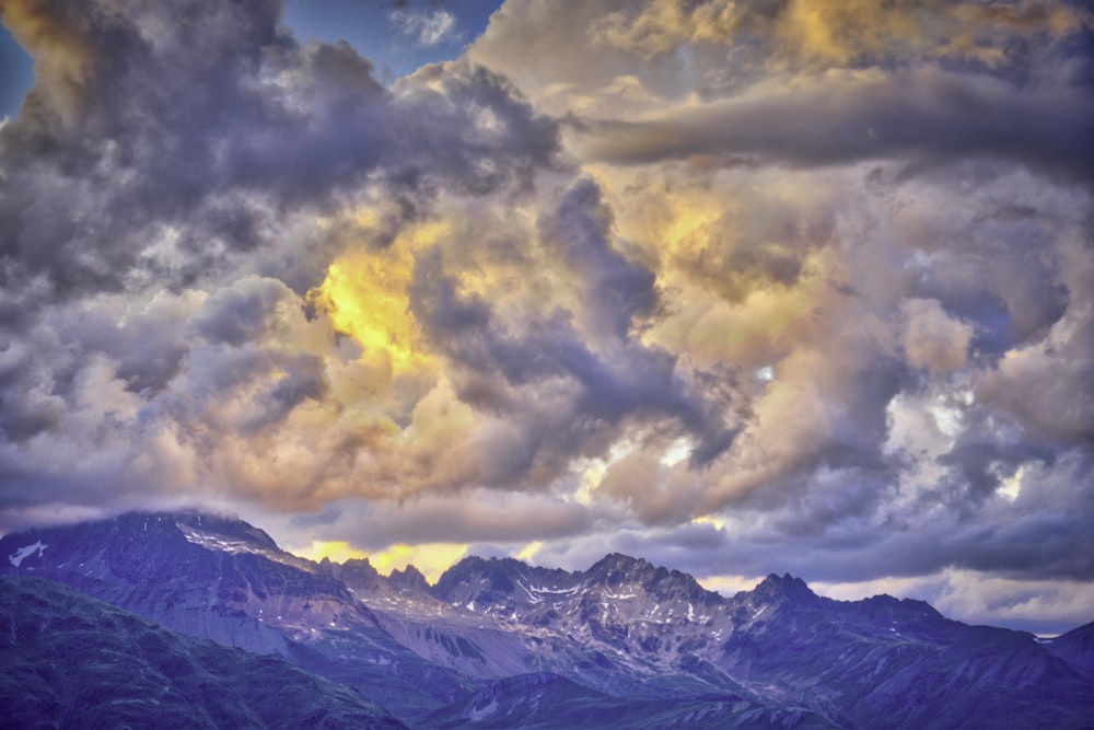 photo of mountain range under golden sky