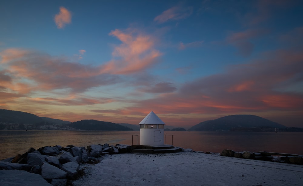 white lighthouse surrounded by body of water