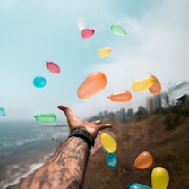 person throwing balloons by Sebastián León Prado (https://unsplash.com/@elmundoderabbit)