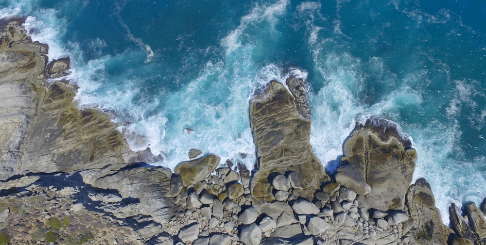 aerial photo of body of water near rock formation