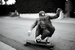 grayscale photography of person riding on longboard