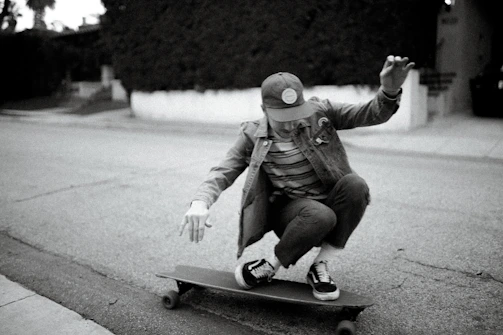 Lifestyle shot of a young person wearing墨境 apparel while skateboarding in a futuristic cityscape.