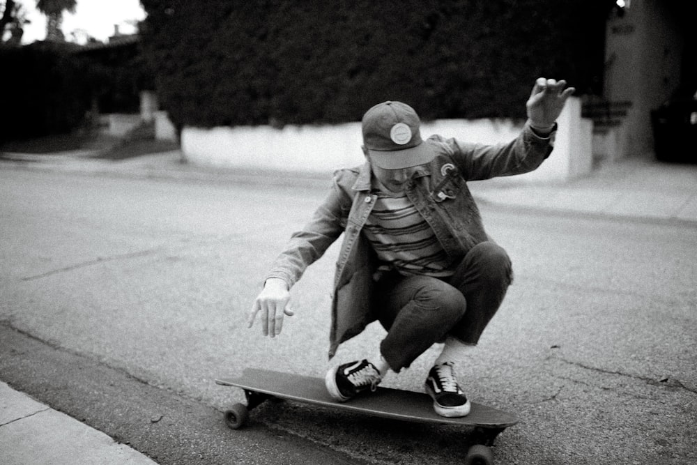 grayscale photography of person riding on longboard