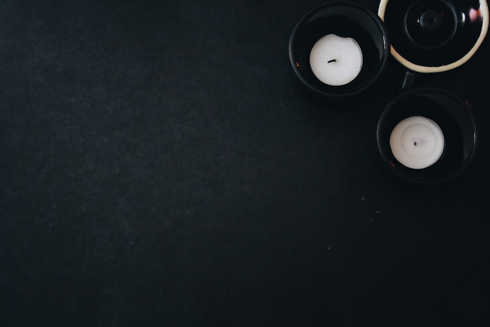 a couple of black candles sitting on top of a table