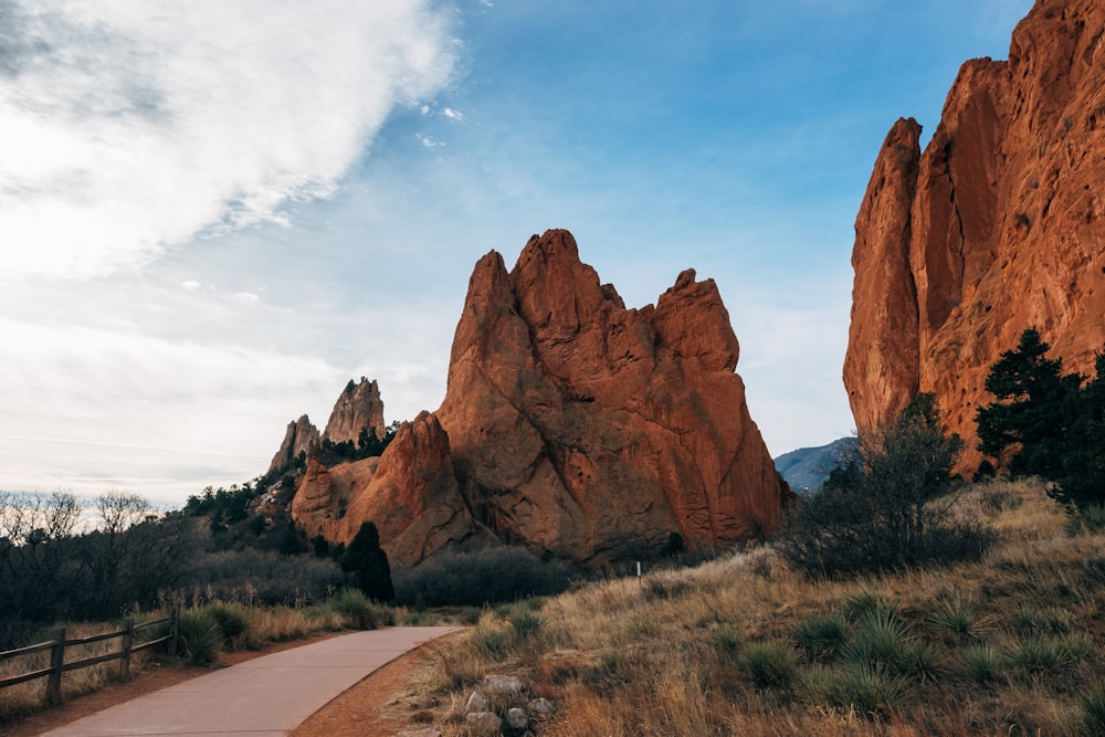 concrete road in the middle two rock formations during daytime