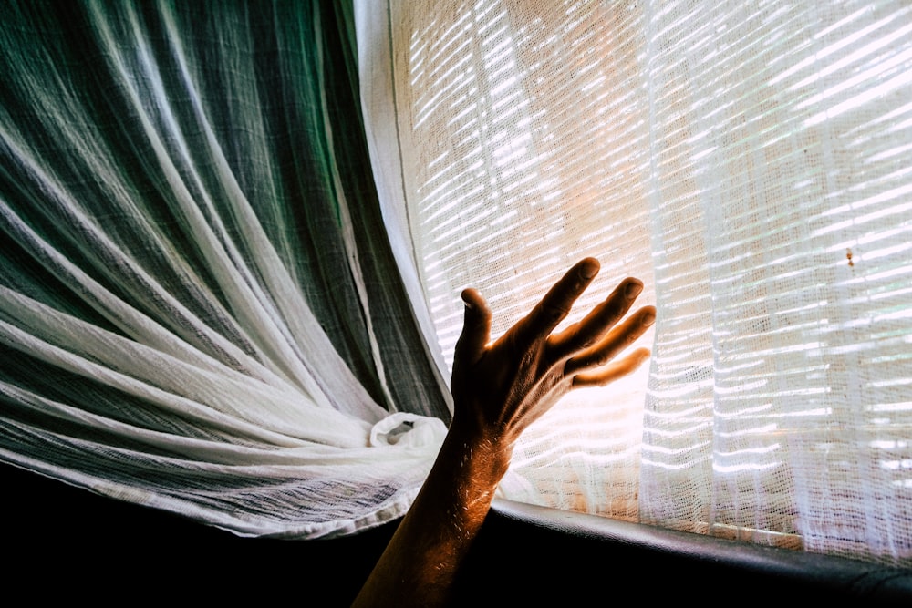 person holding white sheer textile