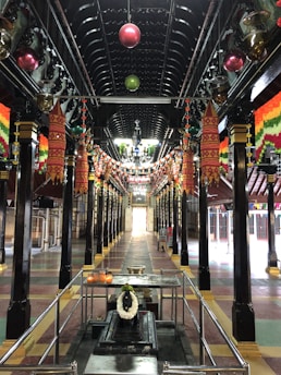 The village community hall adorned with traditional decorations under soft golden lighting.