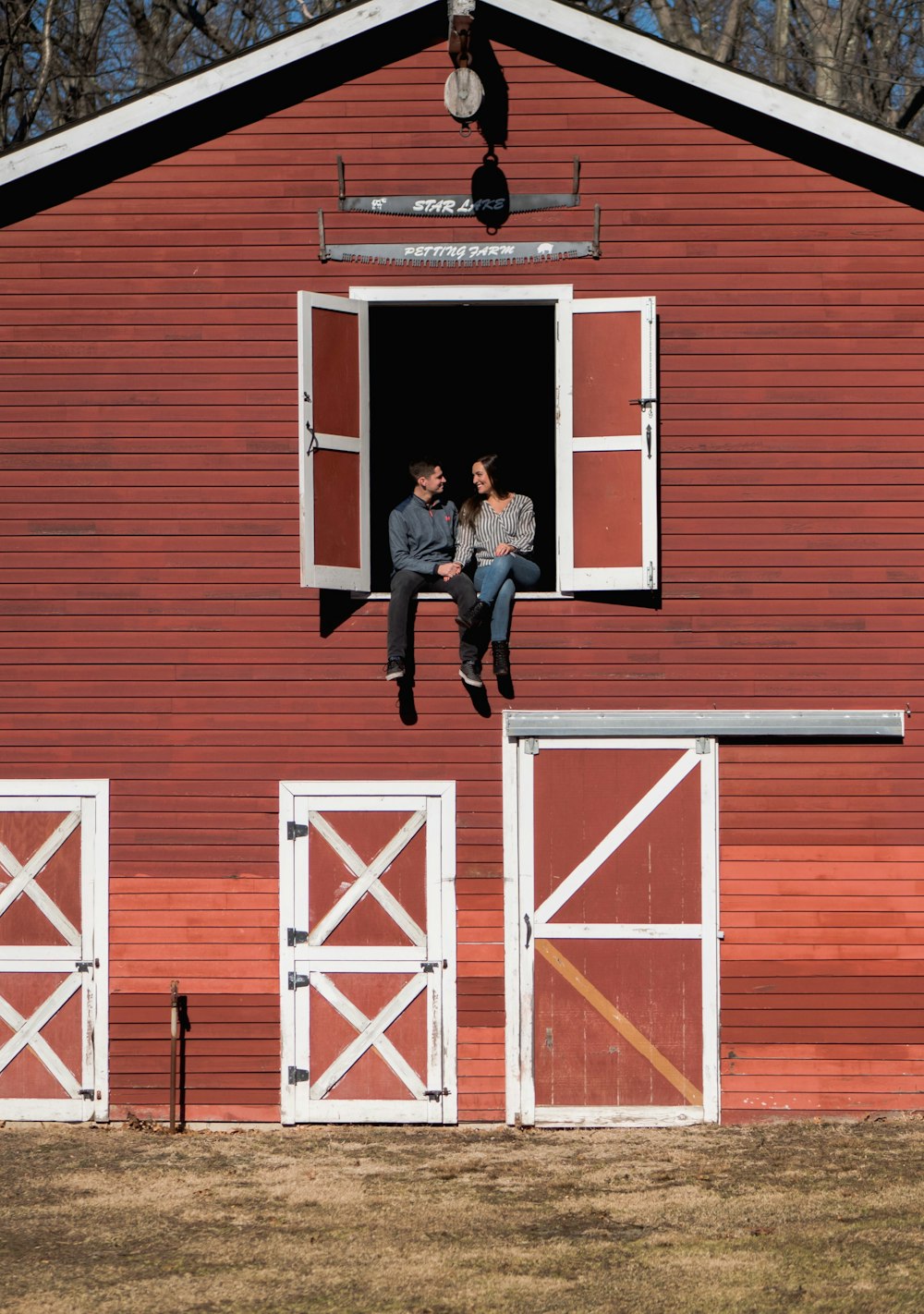 man and woman sitting in stable window