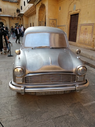 A clean, comfortable Rajputana Holidays vehicle parked near the historic Amer Fort.