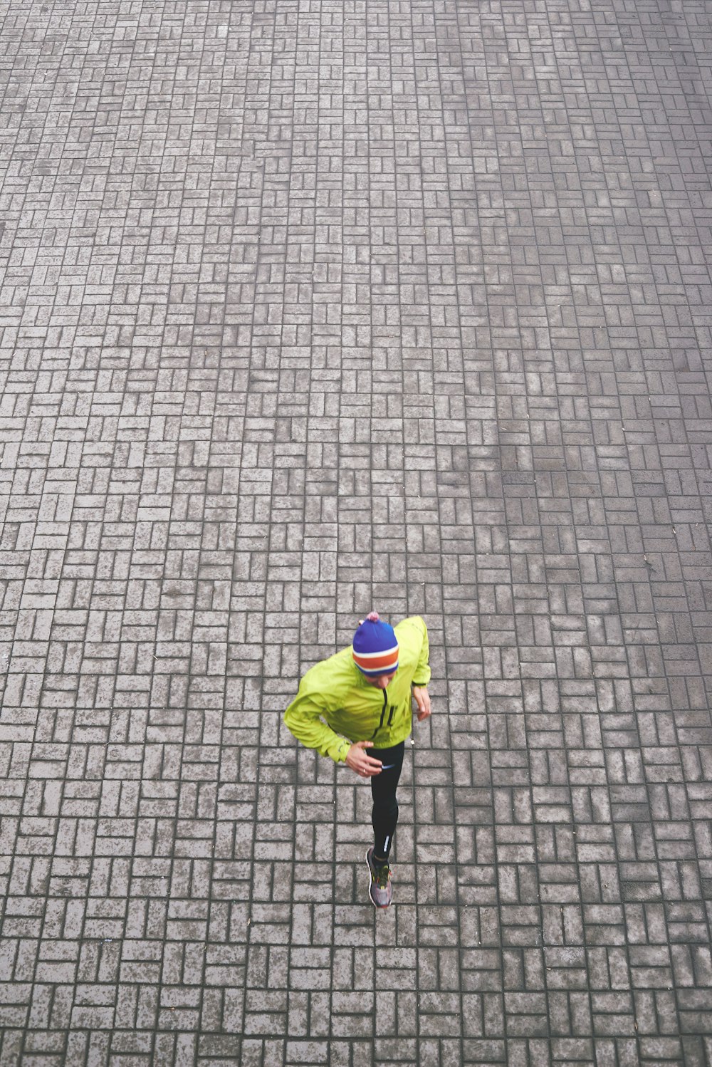 person in green track jacket running