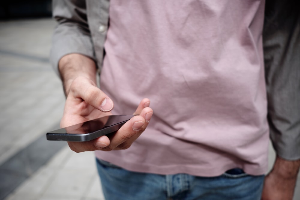 personne tenant le téléphone tout en tenant