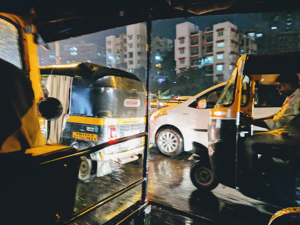 man riding on yellow and black auto rickshaw during daytime