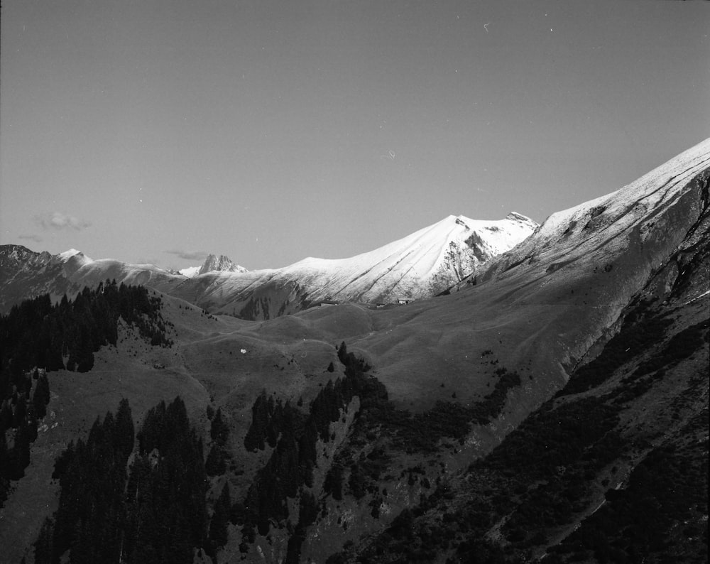 snow covering mountain peaks greyscale photo