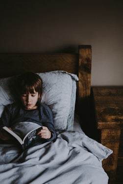 A cozy bedtime scene with a parent reading a storybook to a child under soft lighting.