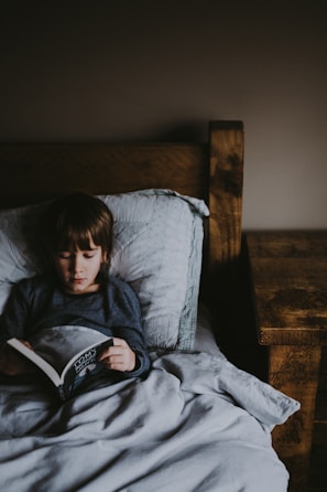 A father reading a bedtime story to his youngest daughter in a cozy room.
