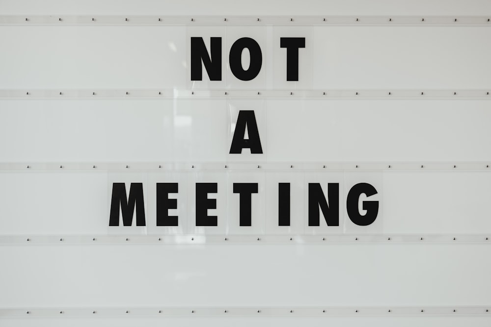 black note a meeting sign on wall
