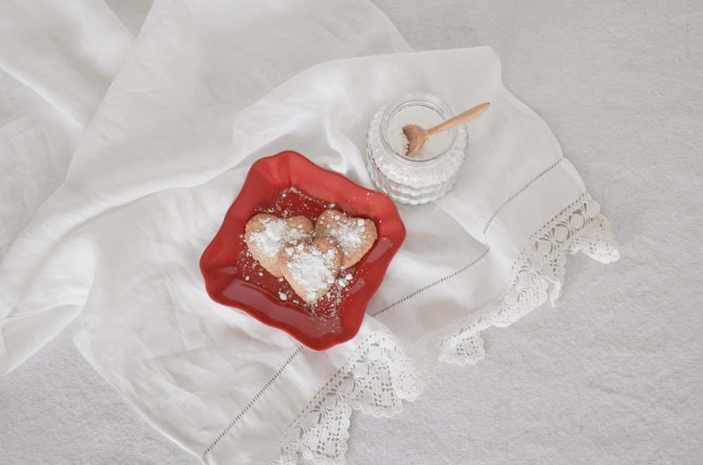 Fotografía plana de galletas en forma de corazón en plato rojo